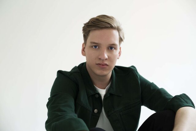 George Ezra Close Up Portrait Wallpaper in Casual Green Jacket