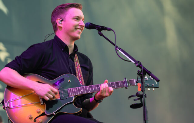 George Ezra Live Performance Playing Guitar Smiling Close Up Wallpaper