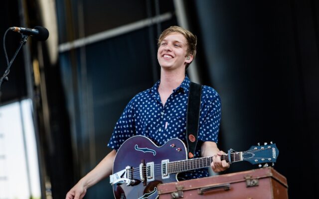 George Ezra performing live with guitar smiling on stage wallpaper