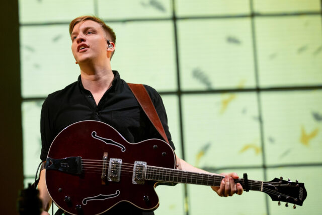 George Ezra playing guitar live on stage in a vibrant concert setting George Ezra wallpapers