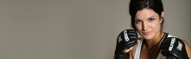 Gina Carano MMA Fighter Focused Pose with Black Combat Gloves Wallpaper