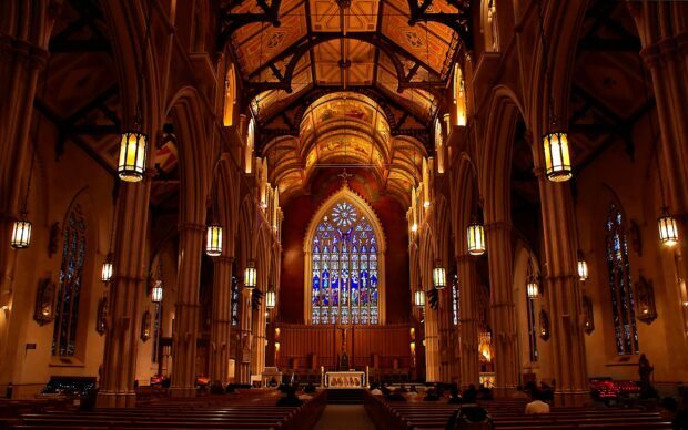 The cathedral features intricate stained glass windows and detailed Gothic architecture, 2K Desktop Wallpaper
