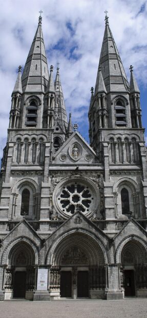A gothic cathedral with intricate stone spires and a round stained glass window, 2K Mobile Wallpaper