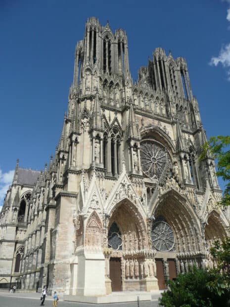 The cathedral features intricate sculptures and large stained glass windows under a clear blue sky, HD Mobile Wallpaper