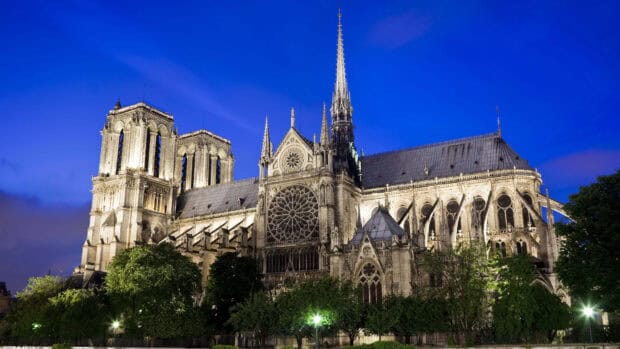 The cathedral shows detailed Gothic architecture under a deep blue sky, 4K Desktop Wallpaper