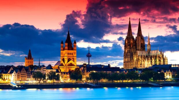 The cathedral stands tall against a vibrant sunset sky over the city, 4K Desktop Wallpaper