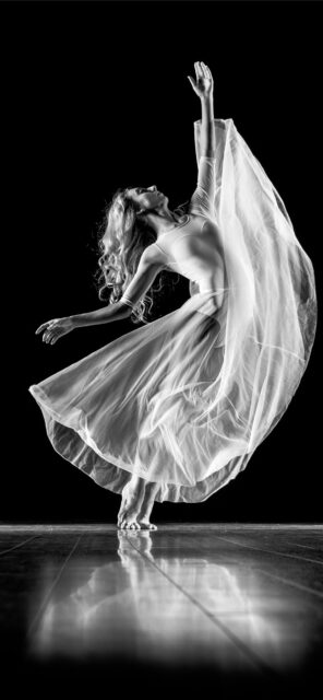 Graceful Contemporary Dance Movement in Flowing White Dress on Black Background Wallpaper