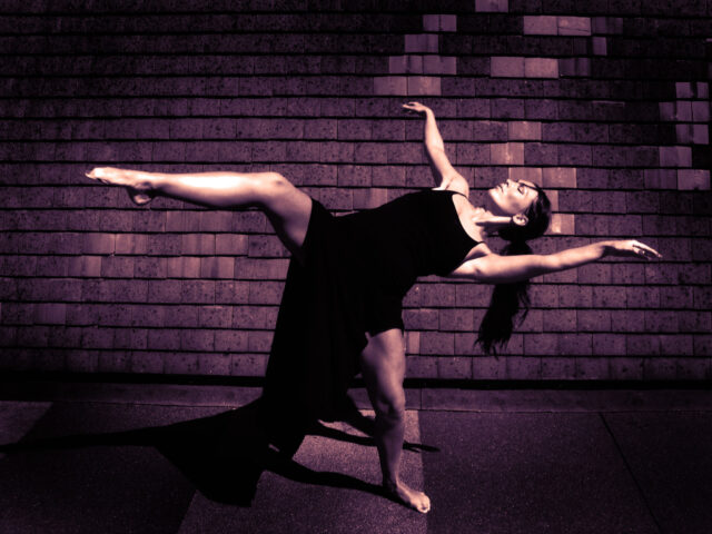 Graceful Contemporary Dance Pose Against Urban Brick Wall Background Wallpapers