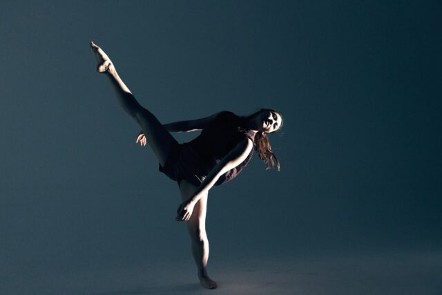 Graceful Female Contemporary Dance Pose in Minimalist Dark Background Wallpaper