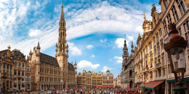 The historic Grand Place with ornate buildings and crowds in Brussels features classic architecture and vibrant city life, HD Desktop Wallpaper