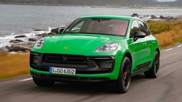 Green Porsche Macan GTS Driving on Coastal Road Premium Wallpaper