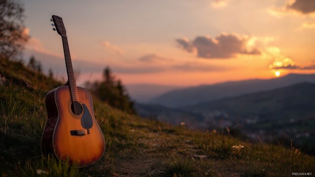 Guitar wallpaper HD, a serene landscape with an acoustic guitar placed on a grassy hill under a sunset glow.
