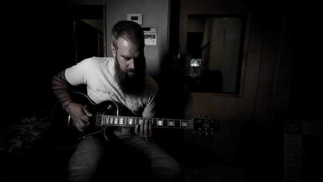Guitarist In Studio Creating In Flames Inspired Music Wallpaper