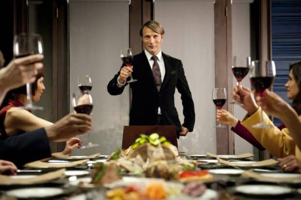 Hannibal Mads Mikkelsen raising a glass in a toast during a formal dinner setting, 2K Desktop Wallpaper
