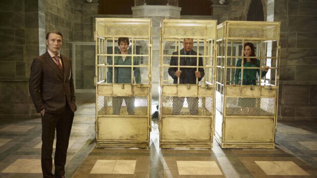 Hannibal Mads Mikkelsen and other characters stand near cages in a large room, 4K Desktop Wallpaper