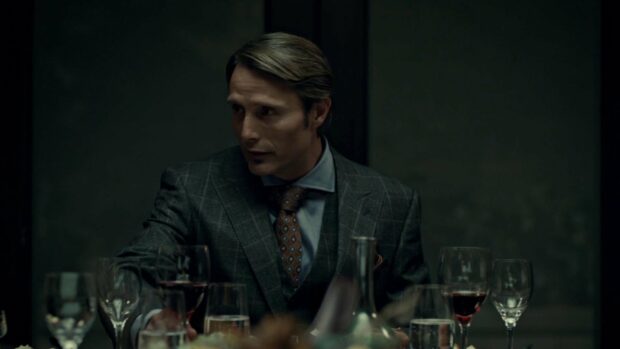 Hannibal Mads Mikkelsen is sitting at a dinner table surrounded by glasses of wine and water, 4K Desktop Wallpaper