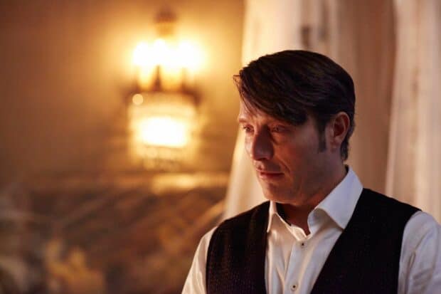 Hannibal Mads Mikkelsen expresses deep thought in a softly lit room, HD Desktop Wallpaper
