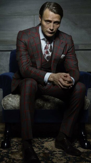 Hannibal Mads Mikkelsen sits thoughtfully wearing a checked suit with a floral tie, HD Mobile Wallpaper