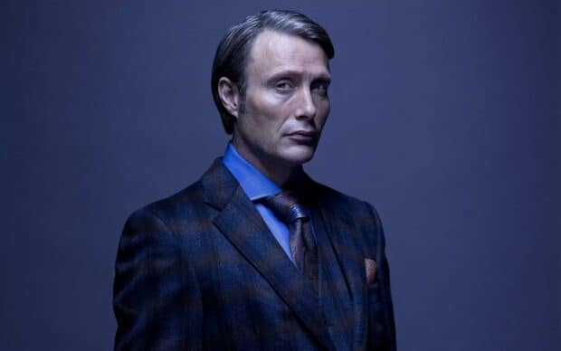 Hannibal Mads Mikkelsen wallpapers showing a serious man in a blue suit looking to the side, 2K Desktop Wallpaper