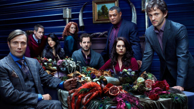 Hannibal TV Series Cast Gathered Around Dark Table with Exotic Food Wallpaper