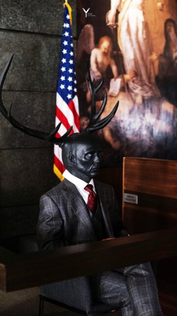 Hannibal TV Series Wallpaper Dark Figure with Antlers in Formal Suit in Courtroom Setting