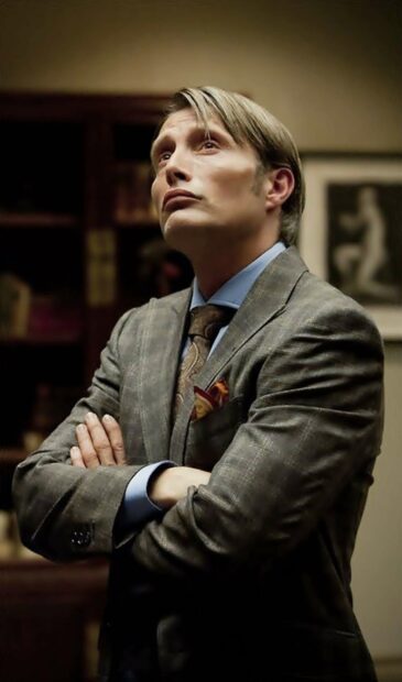 Hannibal Mads Mikkelsen is shown looking upward with arms crossed wearing a suit, HD Phone Wallpaper