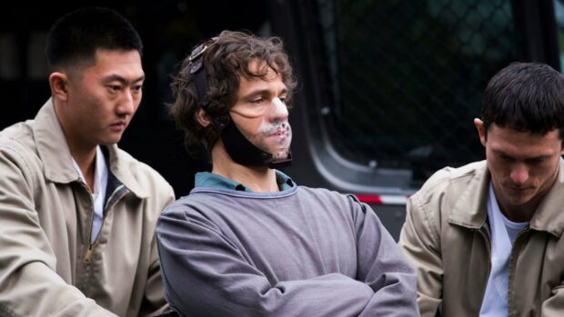 Hannibal Mads Mikkelsen stands secured between two men during tense scene, 4K Desktop Wallpaper