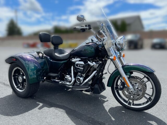 Harley Davidson Freewheeler Trike Parked On An Open Road Background