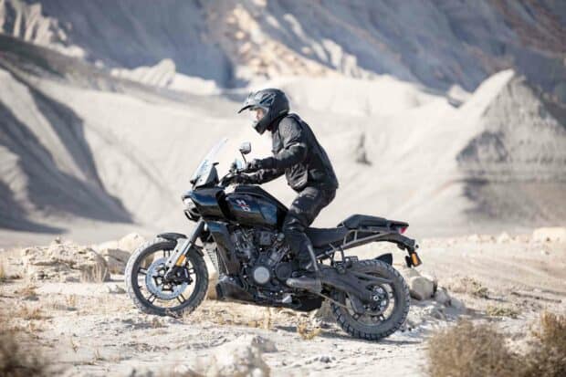 A rider on a Harley Davidson Pan America 1250 motorcycle navigating rocky terrain, HD Desktop Wallpaper