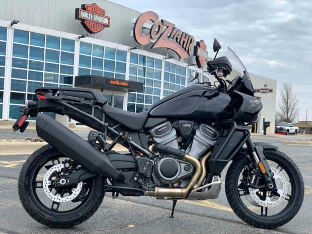 A black Harley Davidson Pan America 1250 stands parked outside a dealership under a cloudy sky, HD Desktop Wallpaper