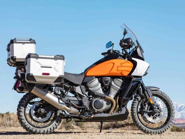 A Harley Davidson Pan America 1250 motorcycle is parked outdoors with rugged tires and storage boxes, HD Desktop Wallpaper