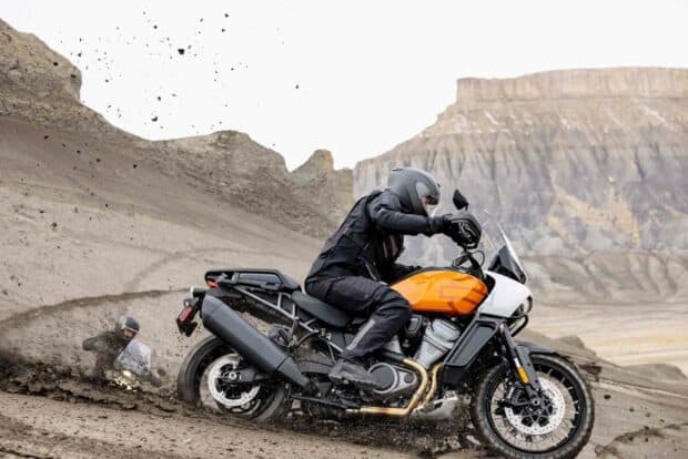 A rider on a Harley Davidson Pan America 1250 riding aggressively through muddy terrain, HD Desktop Wallpaper