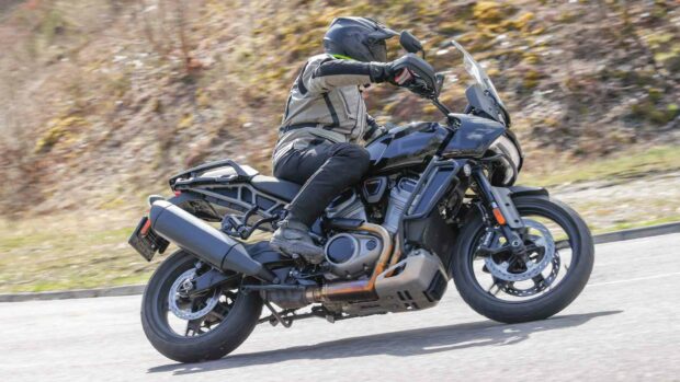 A rider on a Harley Davidson Pan America 1250 motorcycle is making a turn on the road, HD Desktop Wallpaper