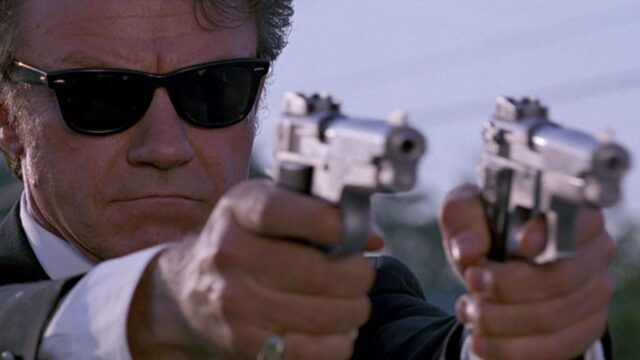 Harvey Keitel In Iconic Action Scene Holding Dual Guns Wallpaper