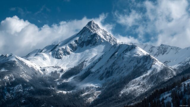 High res wallpaper HD widescreen, a breathtaking view of a snowy mountain peak against a bright blue sky.