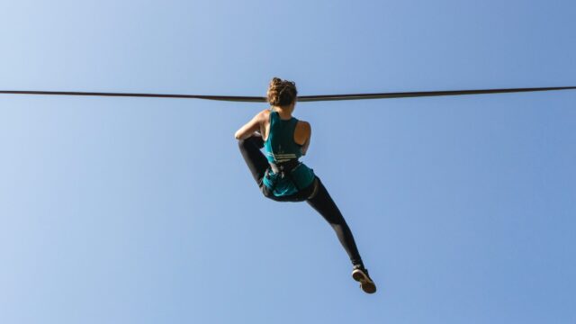 Highline Slacklining Woman Balancing on Slackline Against Clear Blue Sky Background