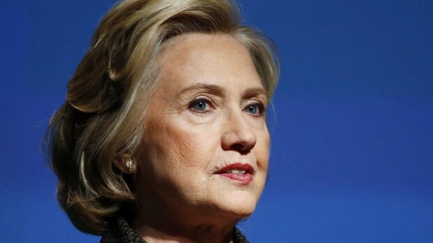 Hillary Clinton looks serious against a blue background, HD Desktop Wallpaper