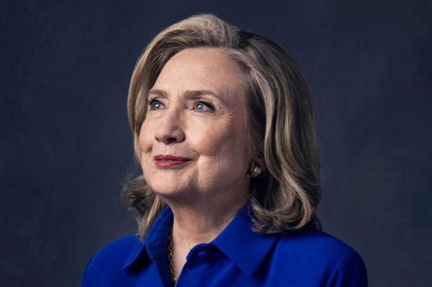 Hillary Clinton wears a blue shirt with a thoughtful expression on a dark background, HD Desktop Wallpaper