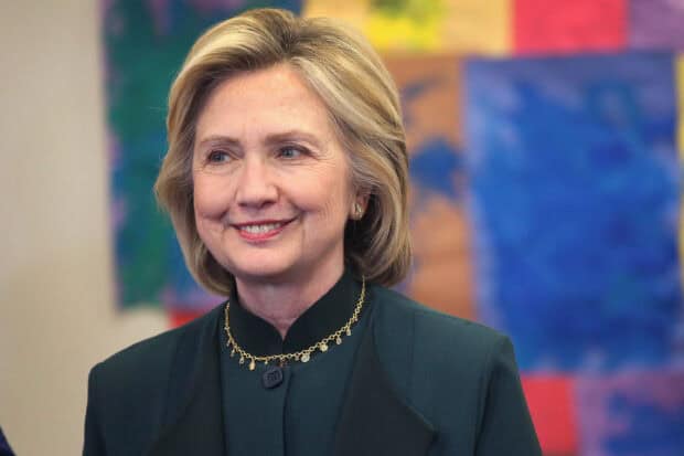 Hillary Clinton is smiling with colorful artwork in the background, 2K Desktop Wallpaper