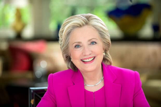 Hillary Clinton is wearing a bright pink blazer and smiling warmly in a well lit room, HD Desktop Wallpaper