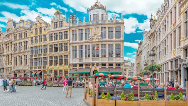 People enjoying outdoor cafes in Brussels with historic buildings in the background, 2K Desktop Wallpaper
