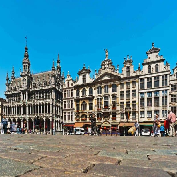 The Brussels scene captures historic buildings with people walking on the cobblestone square under clear blue sky, HD Mobile Wallpaper