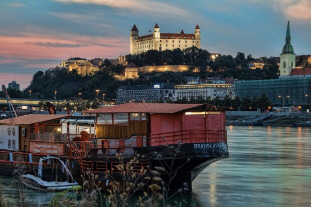 A scenic view of Bratislava with a castle and river at sunset, HD Desktop Wallpaper