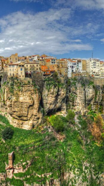 A historic village is perched on a cliffside surrounded by lush greenery in this Algeria Wallpapers scene, HD Mobile Wallpaper