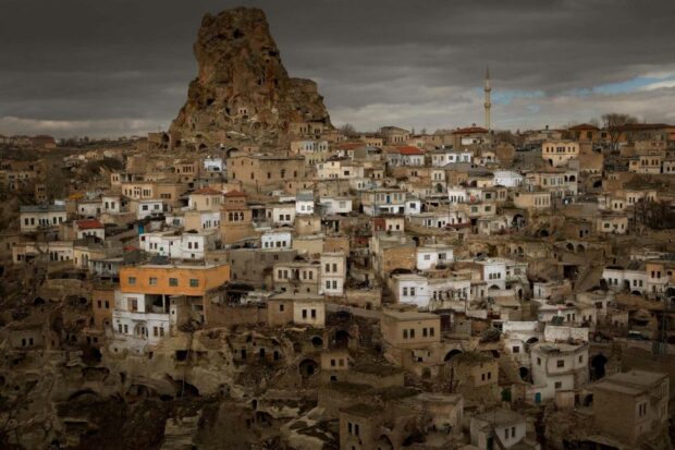 A panoramic view of old houses and rock formations in Cappadocia under a cloudy sky, HD Desktop Wallpaper