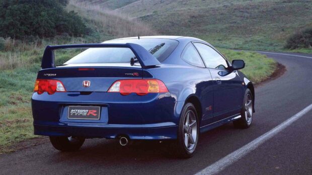 A blue Honda Integra Type R is parked on a curved road with grass fields around, HD Desktop Wallpaper