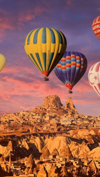 Hot air balloons float peacefully over the unique rocky landscape of Cappadocia at sunset, HD Phone Wallpaper