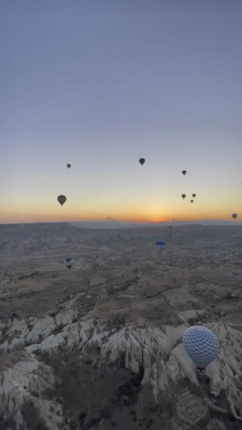 The Cappadocia Wallpapers show hot air balloons flying above the rocky terrain at sunrise, 4K Phone Wallpaper