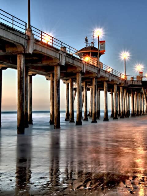 Huntington Beach Pier at Sunset with Glowing Lights and Ocean Reflection Wallpaper