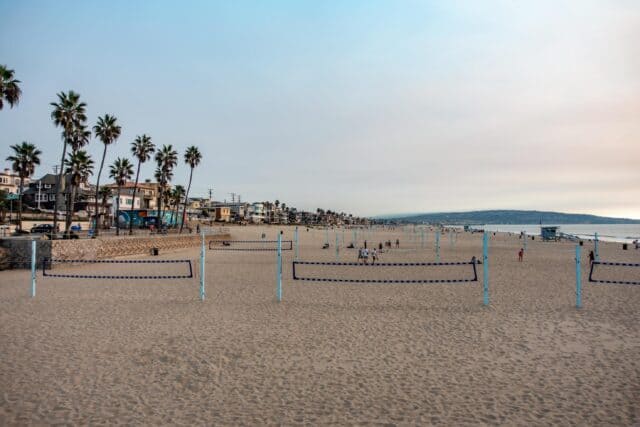 Huntington Beach Volleyball Courts with Palm Trees and Ocean View Wallpaper